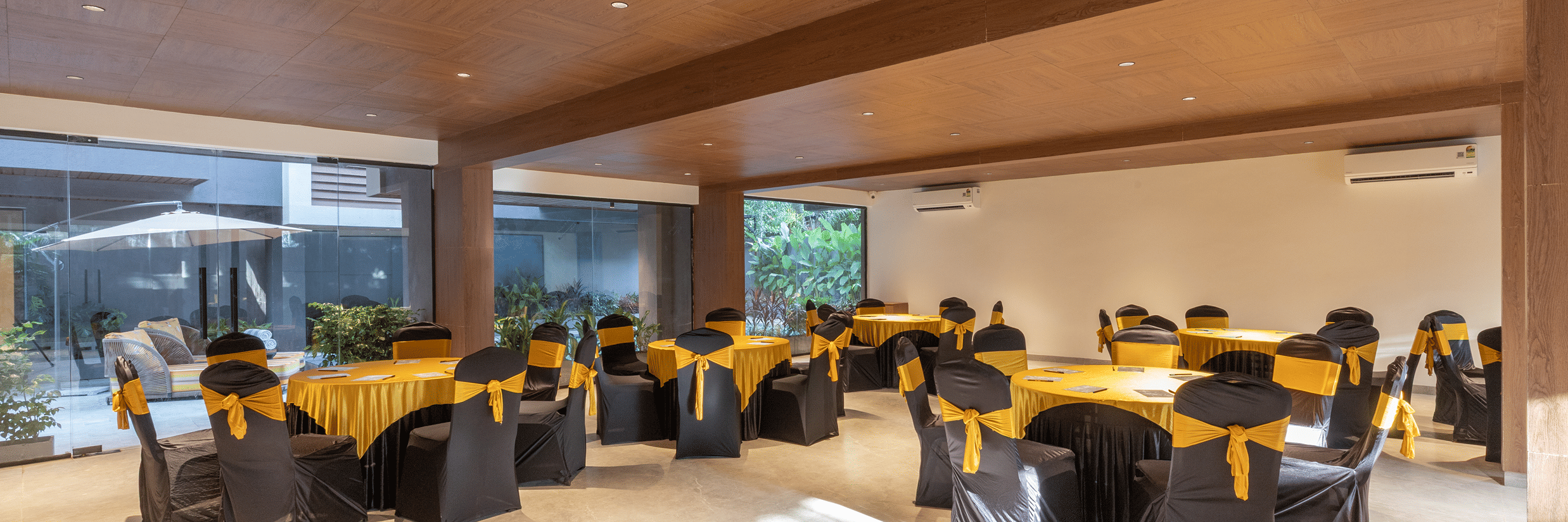 Meeting room arranged with round tables and yellow covers for corporate events at Sibaya Courtyard By Stone Wood Premier.
