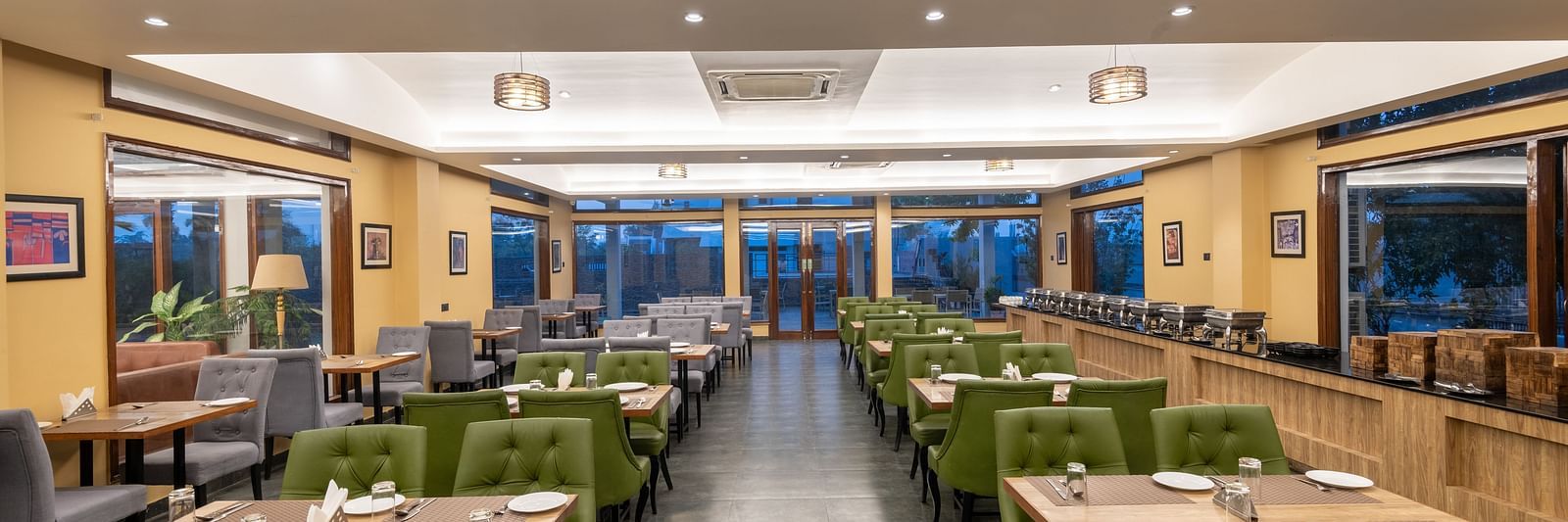 View from one end of the dining area at DLS Forest Vines Resort, with tables and chairs neatly set on both sides.