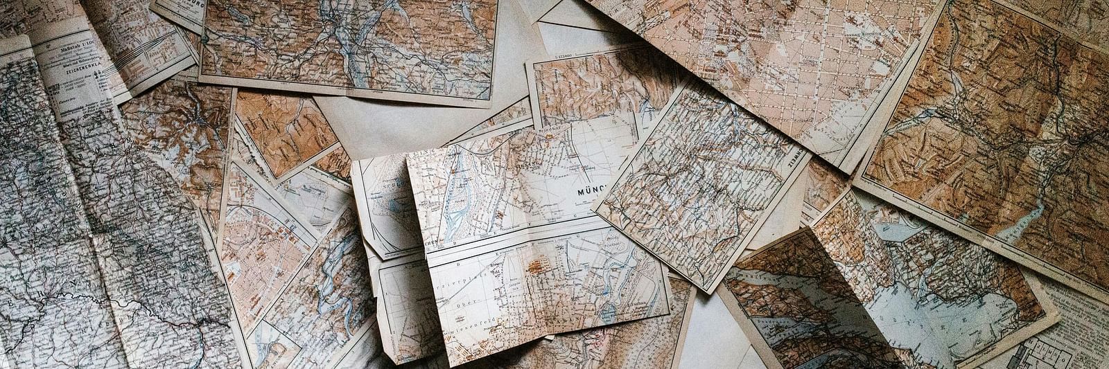 Several old texts and pages of a diary scattered on a floor.