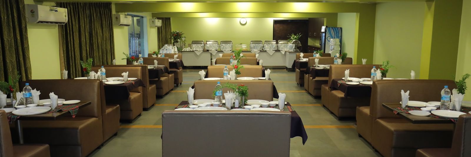 Multiple dining tables arranged in rows at Krushnai Resort restaurant.