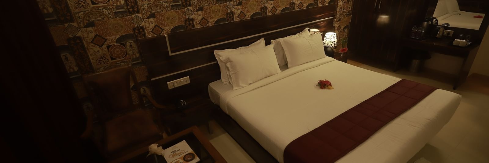 A Deluxe Room of Mountview Resort furnished with a king size bed, a wardrobe, bedside tables, and a seating area.
