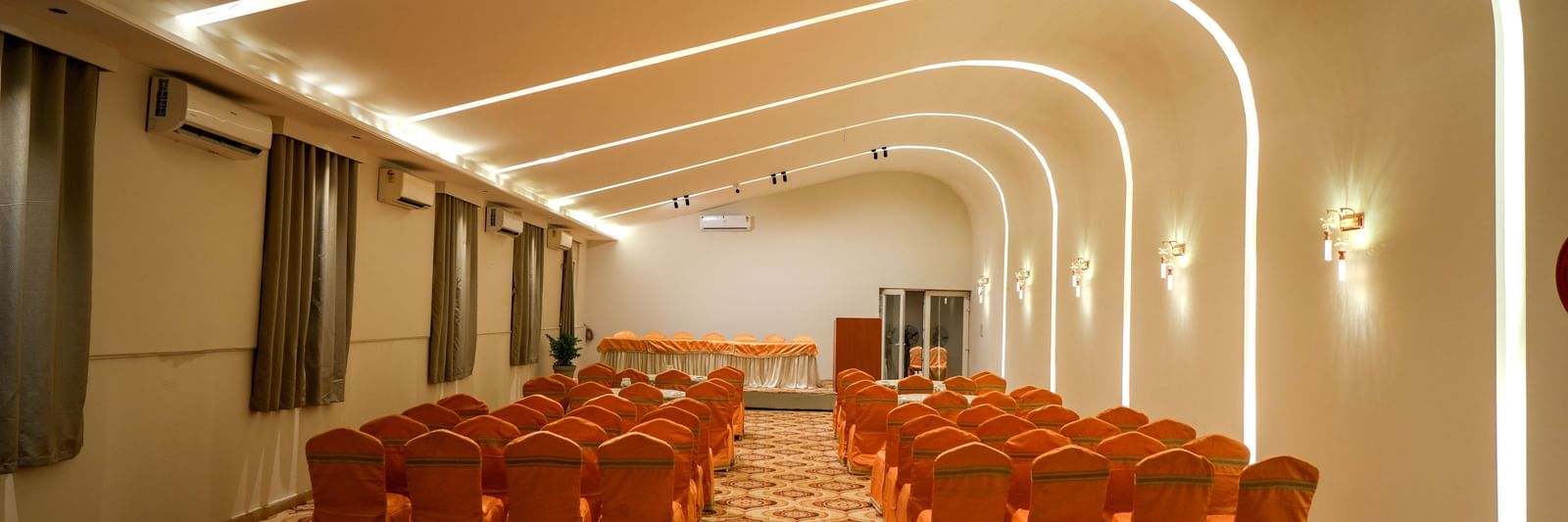 Modern banquet hall with elegant seating and ambient lighting at Pravasa Hotel Kolhapur.