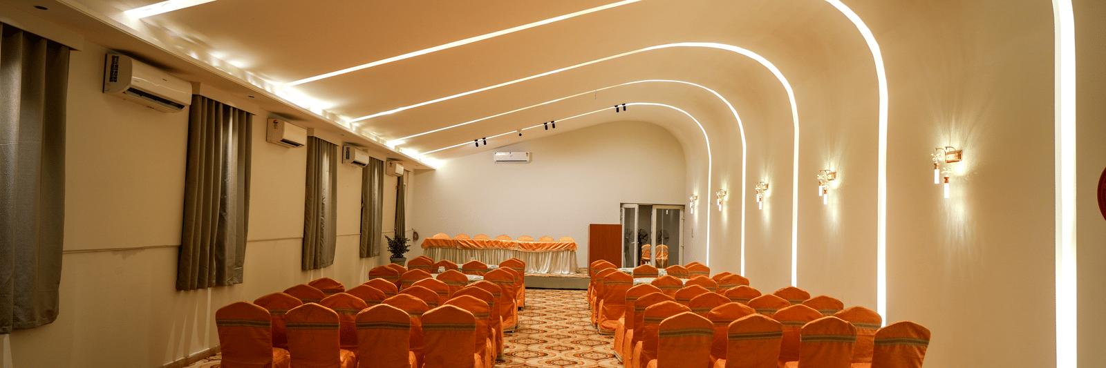 Conference hall with chairs arranged in rows at Pravasa Hotel, Kolhapur.