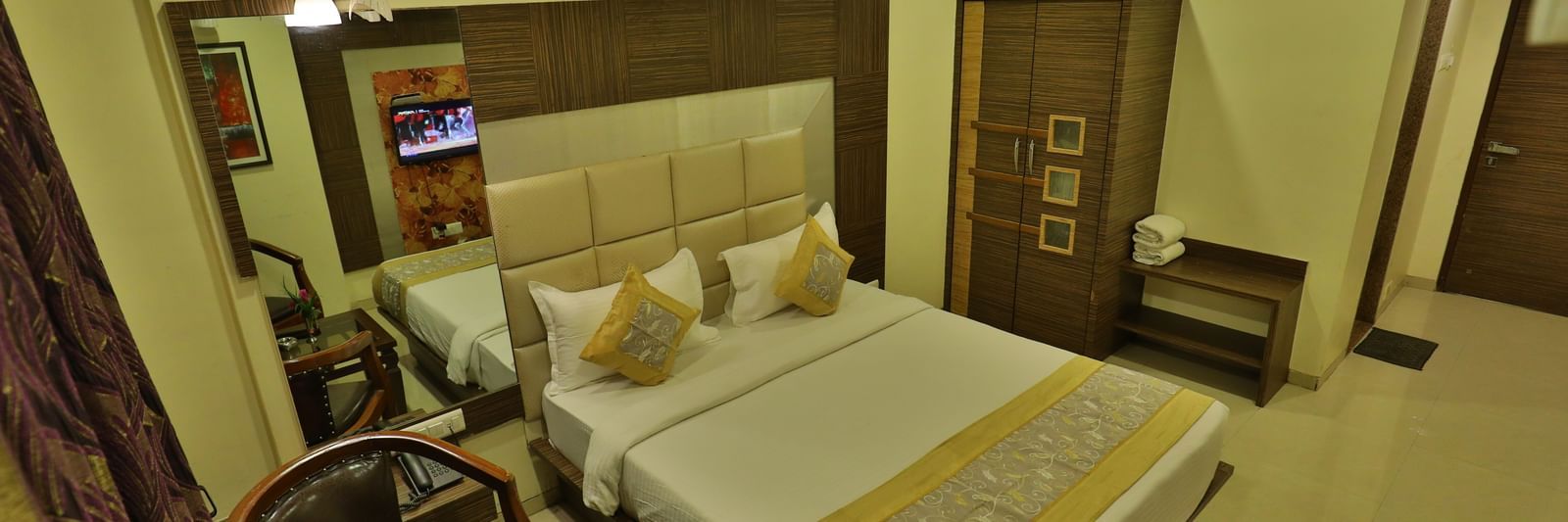 An expansive view of a well-appointed hotel room featuring a bed, seating, and contemporary decor - Retreat Heritage, Lonavala