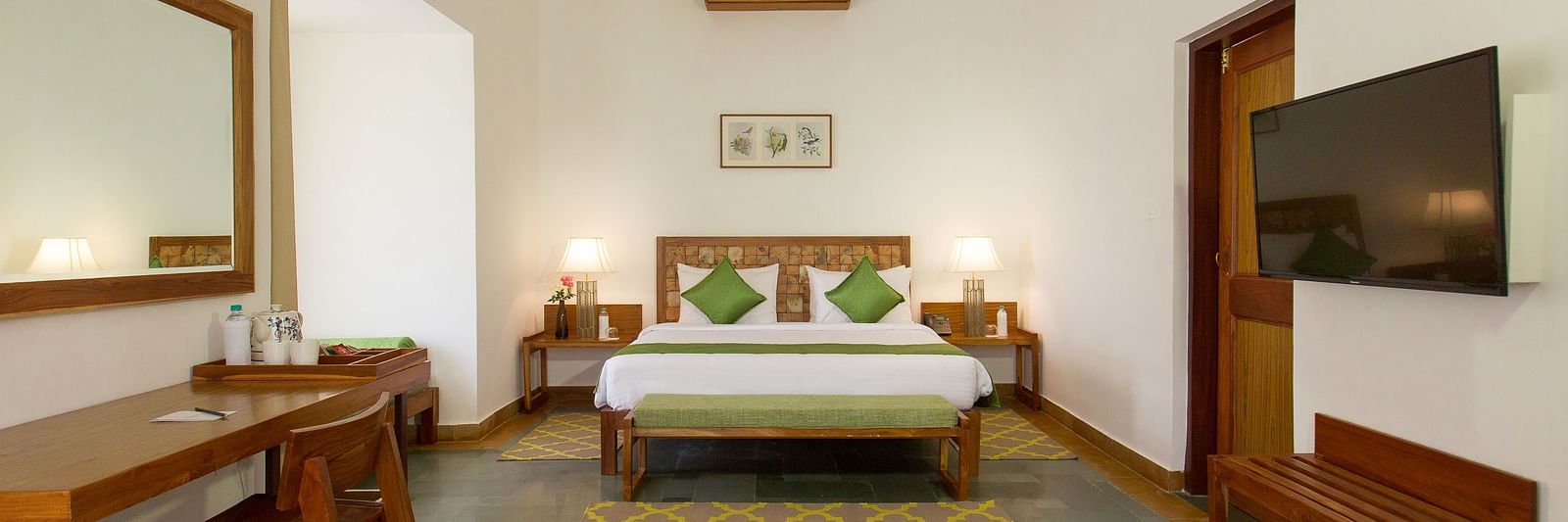 A room at Saraca Resort & Spa Corbett with a double bed, a television and a work desk and chair