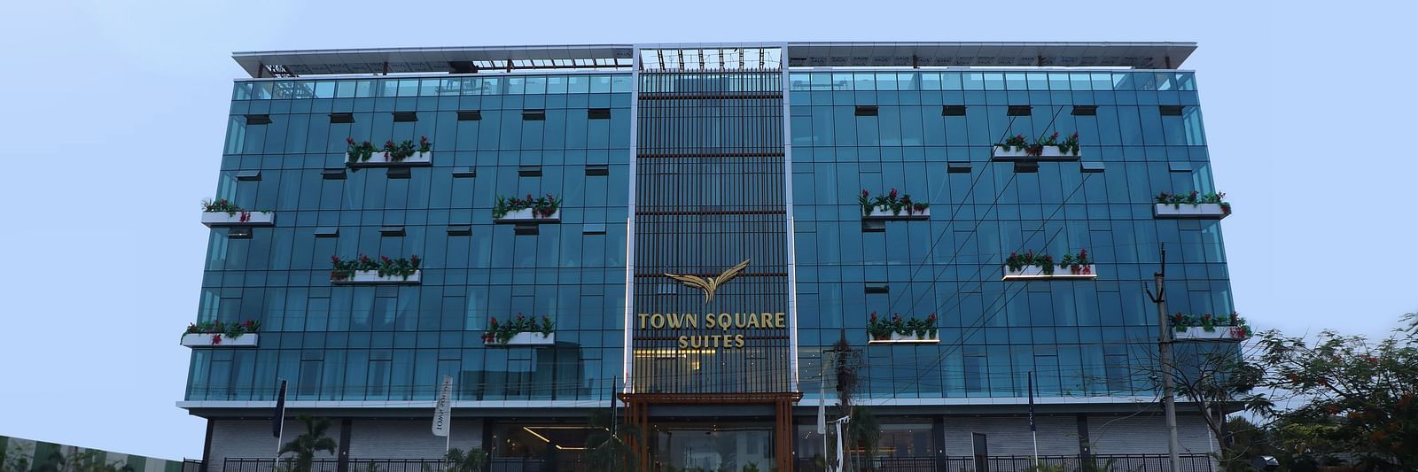 Exterior view of Town Square Suites showing modern architectural design and lush green lawn