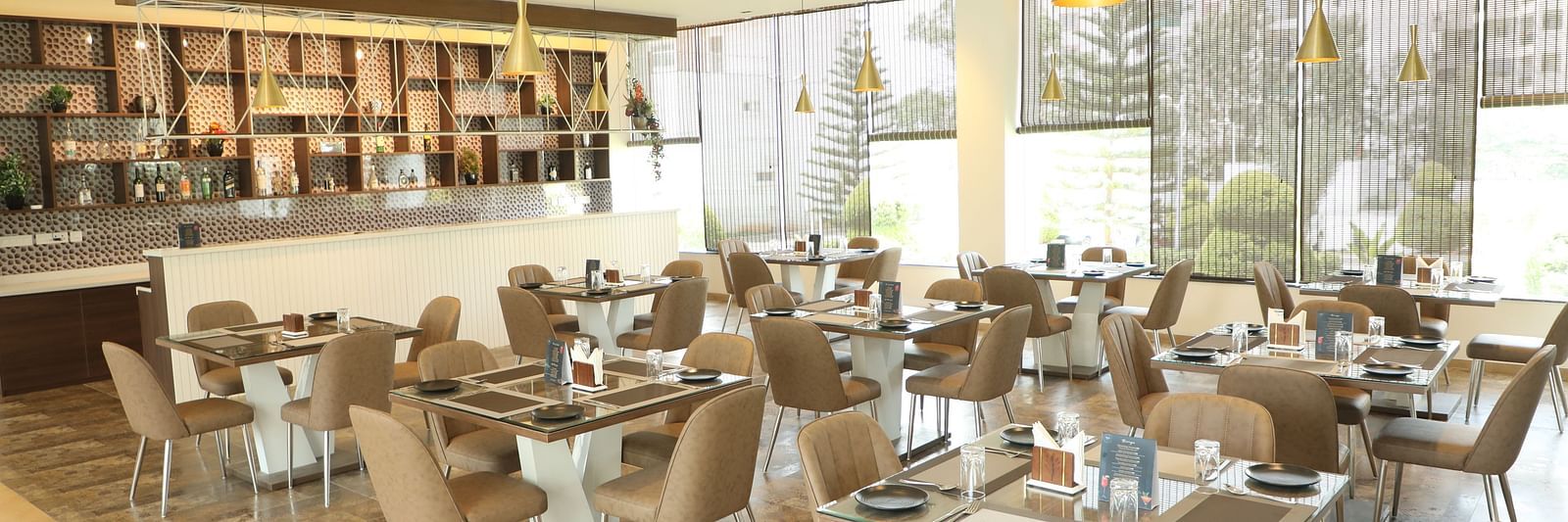 Brown tables and chairs in a restaurant dining area - Welcome Inn Hotels