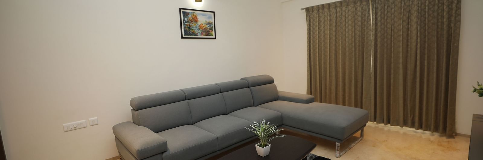 Grey couch with black table in front and matching carpet on the floor - Welcome Inn Hotels