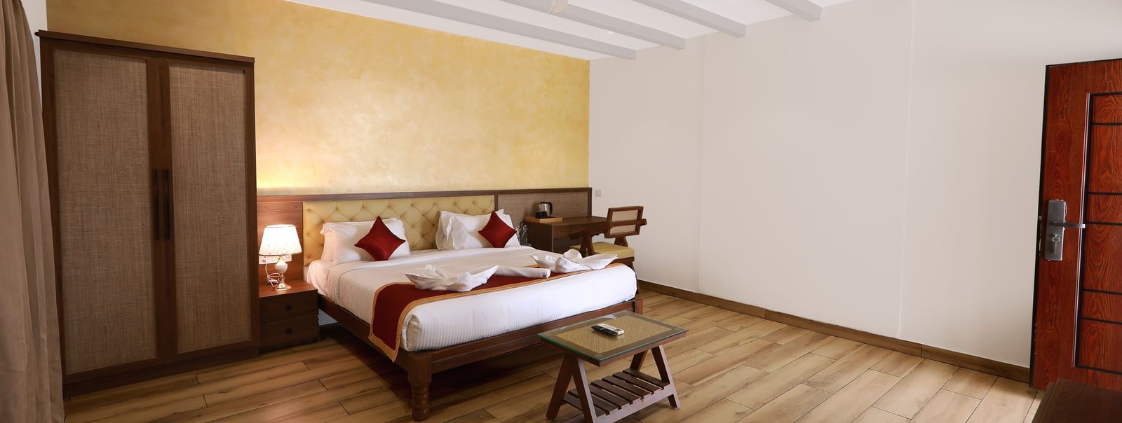 Full view of an expansive bedroom featuring a double bed along with a wardrobe in the Terrace Cottage at WOW Naturefull Resorts, Yercaud.