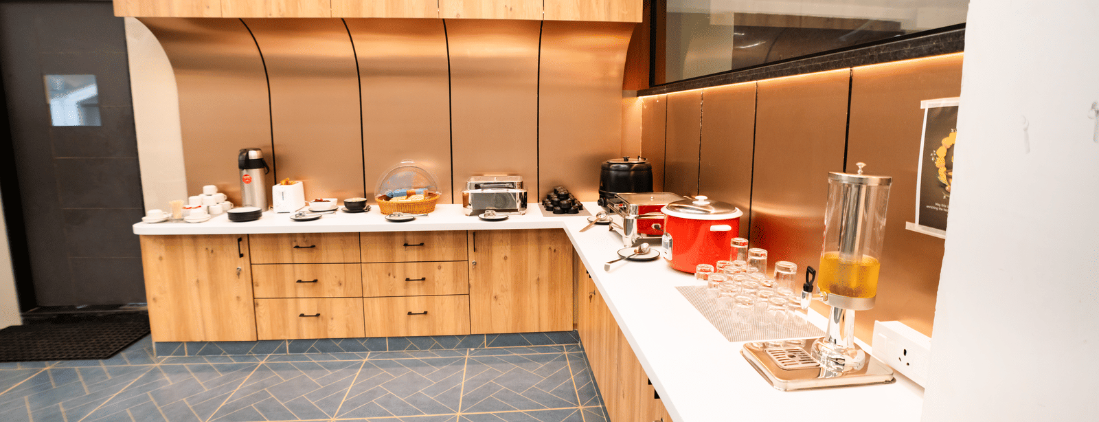 Buffet counter with food trays, plates, and serving utensils arranged neatly at Sunrise Business Hotel, Hyderabad.