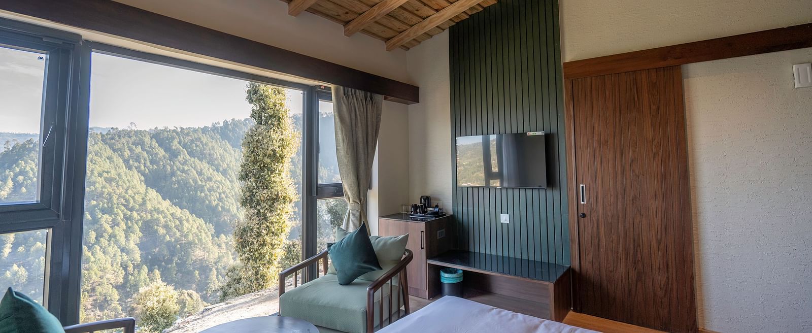 Modern bedroom with a large window showing a scenic view at The Chamomile Estate.