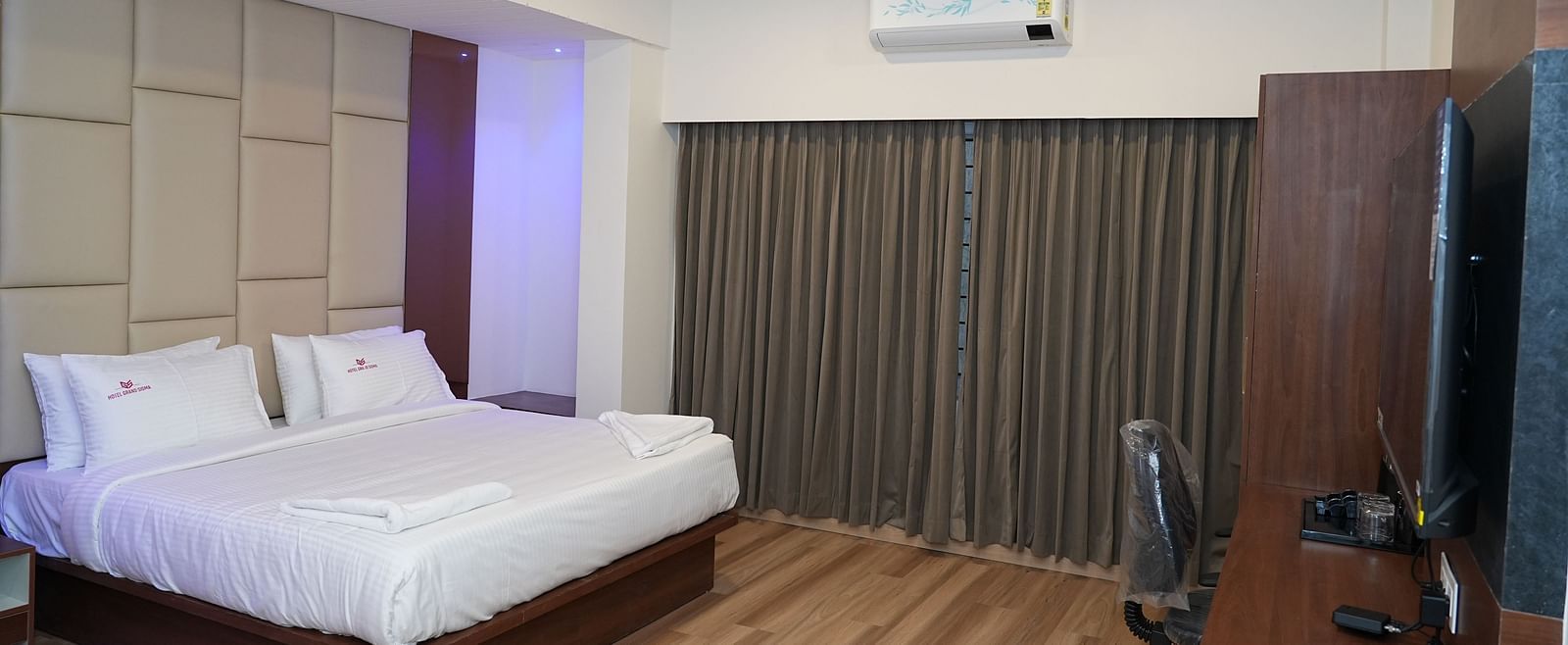 full view image of the suite featuring a split wall mounted air-conditioner along with a double bed in the middle of the room - Hotel Grand Sigma