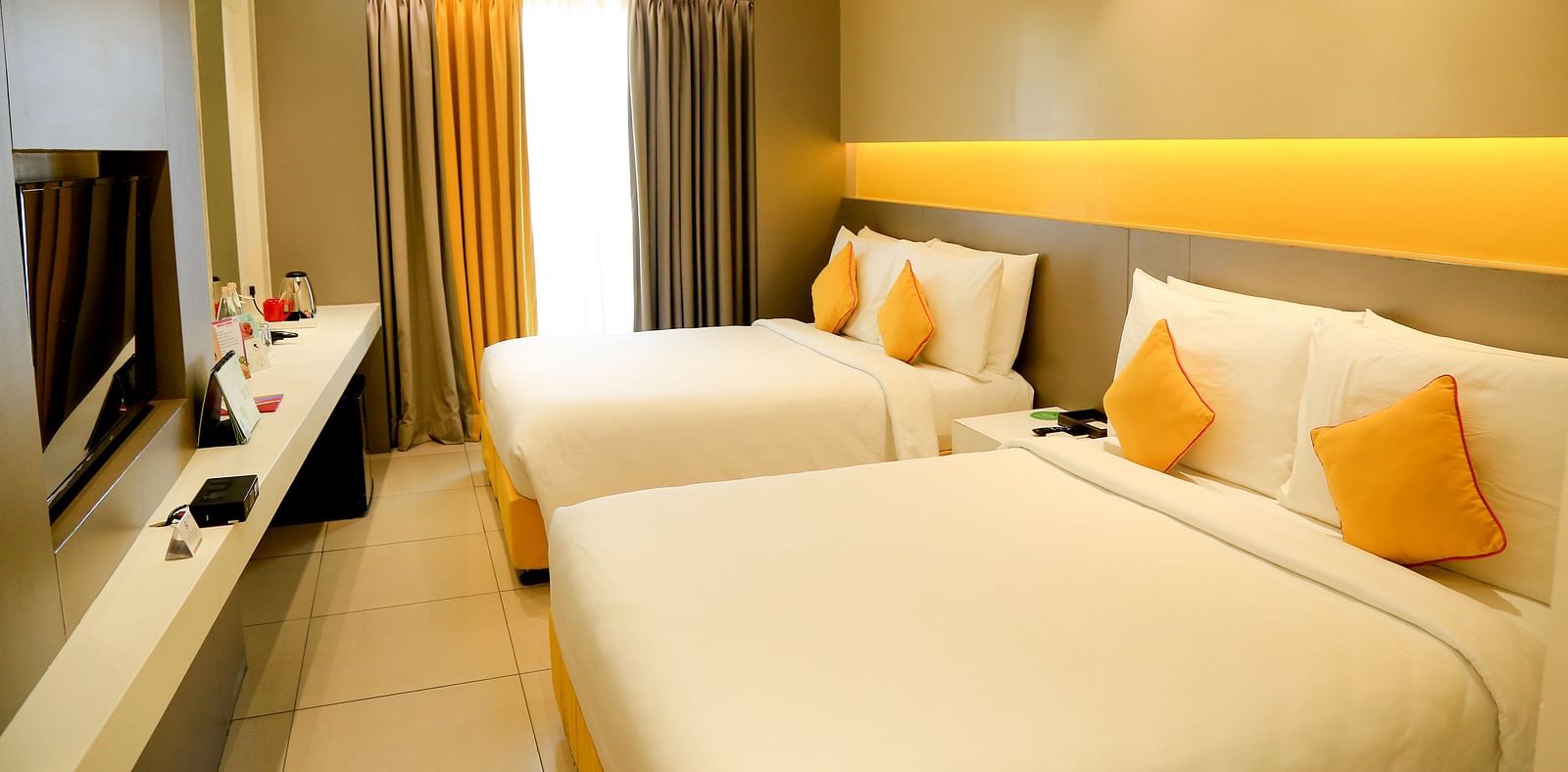 Spacious twin beds with headboards line the wall, large windows with curtains cover them