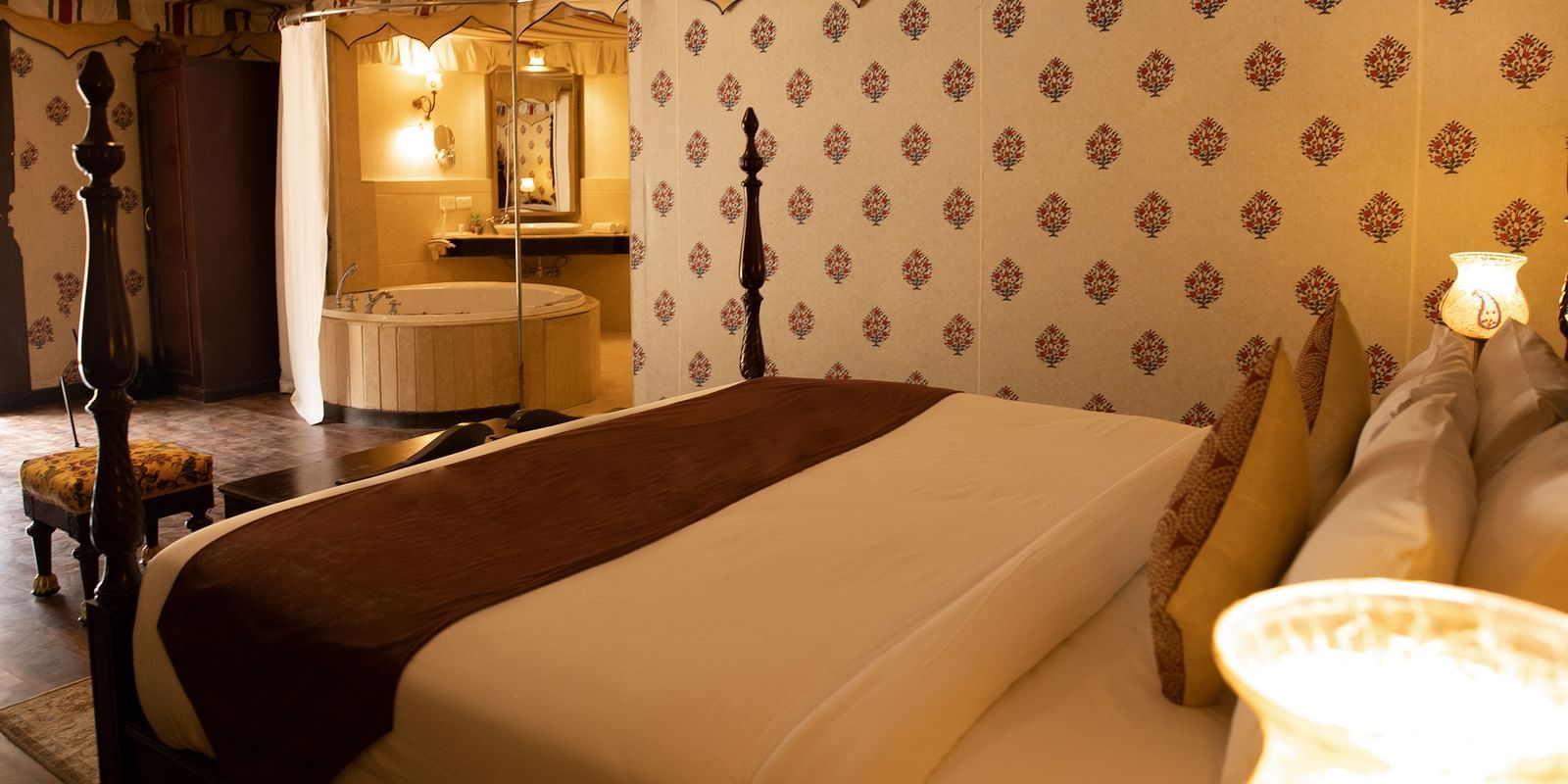 Side view of a room with a bed and lamps beside the bed at Rajasthali Resort & Spa Jaipur.