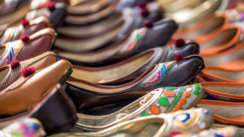 Multiple pairs of colorful Jutti, a type of open shoes, arranged neatly in rows