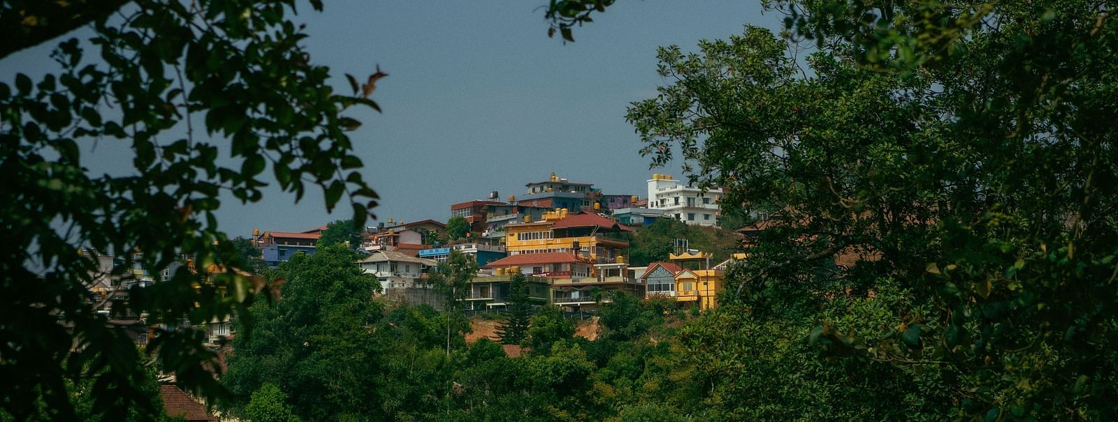 image of the city of coorg with vibrant and colourful buildings surrounded by lush greenery