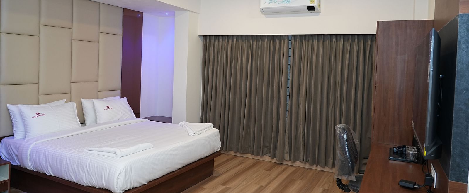 full view image of the suite featuring a split wall mounted air-conditioner along with a double bed in the middle of the room - Hotel Grand Sigma