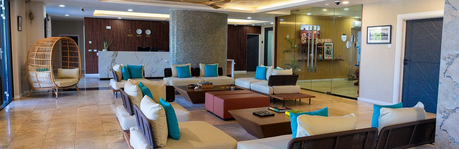 An overview of a hotel lobby in Montego Bay featuring ambient lighting, cosy and contemporary looking sofas placed around a table - Hotel 39, Jamaica (Montego Bay)
