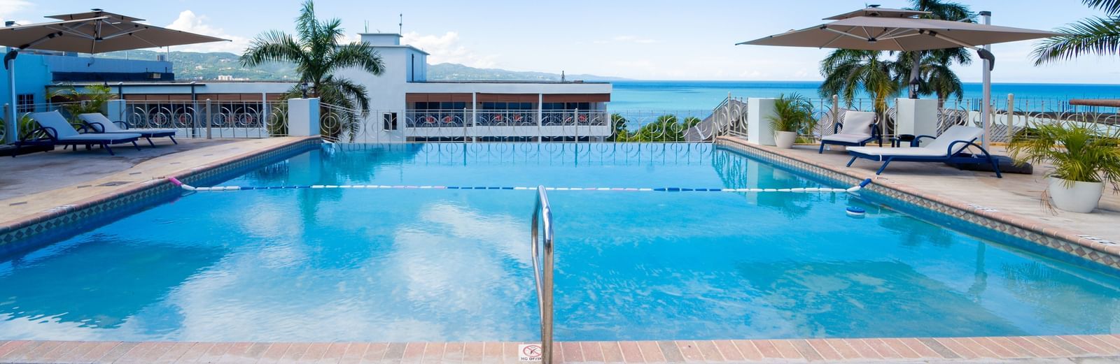A close up shot of a pool with clear water and views of Montego Bay in the background - Hotel 39, Jamaica (Montego Bay)