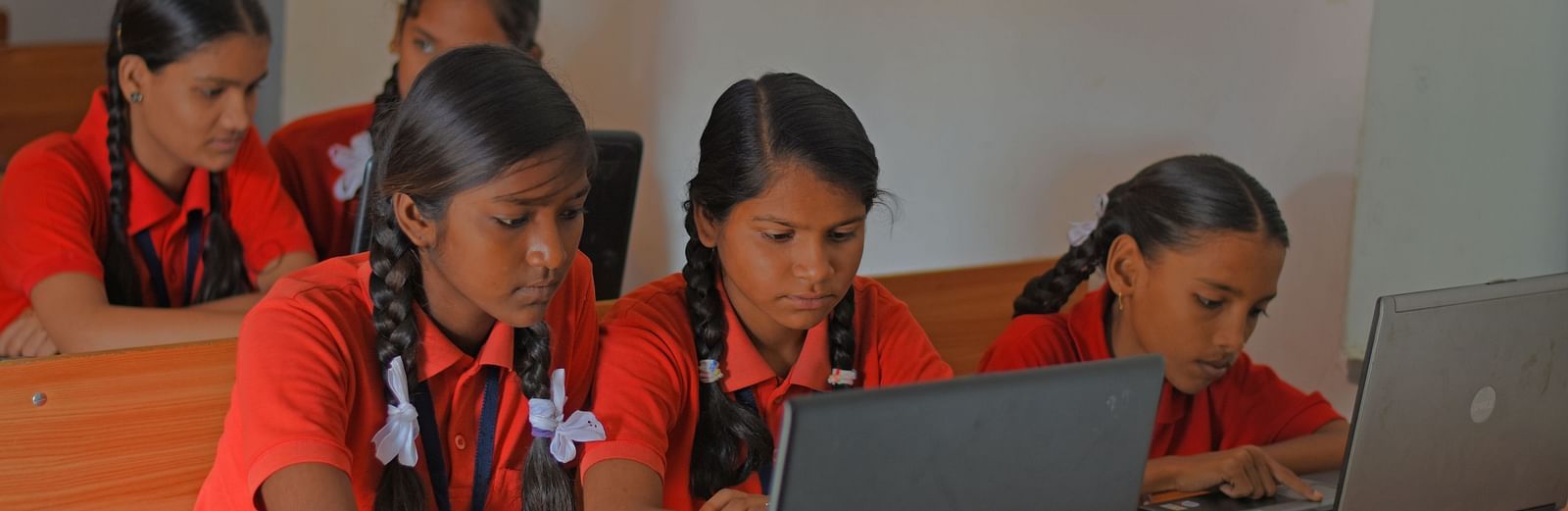 An image of two girls looking into the laptop- Shahpura Bagh.
