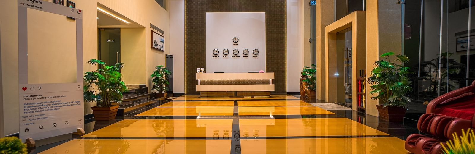 A brightly lit hotel hallway with polished floors and plants | Mansha Hotels
