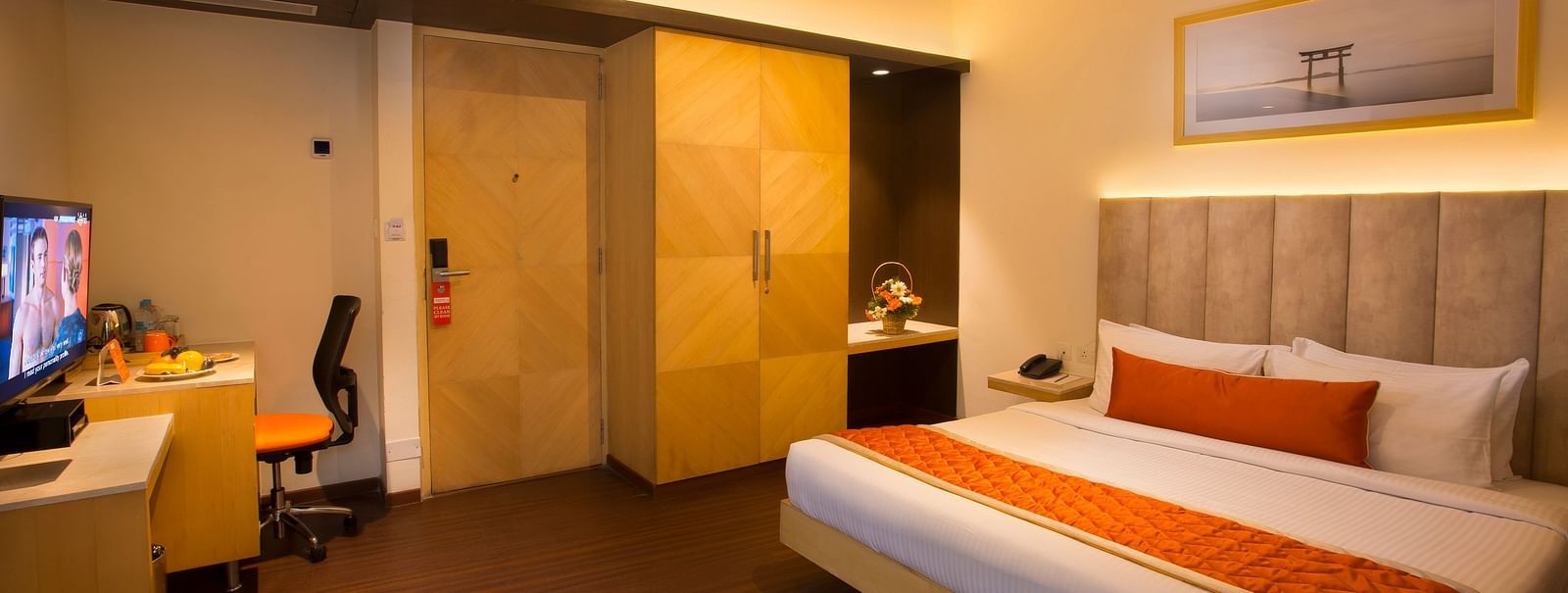 A spacious hotel room with a comfortable bed, ambient lighting and a television, featuring a wooden wardrobe and desk - Hotel Langford Keys by TGI, Shanti Nagar