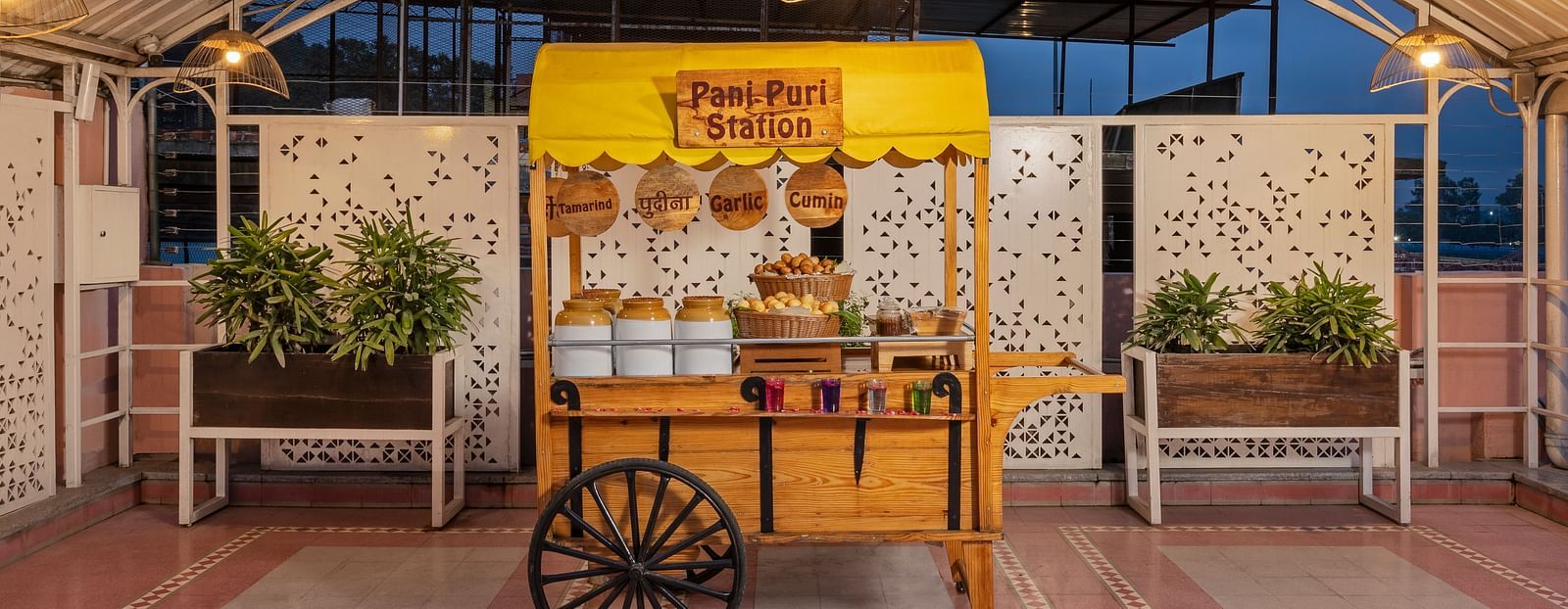 Charming indoor dining area of The Patio café at Ganga Lahari, featuring local décor and a vegetarian food cart setup.