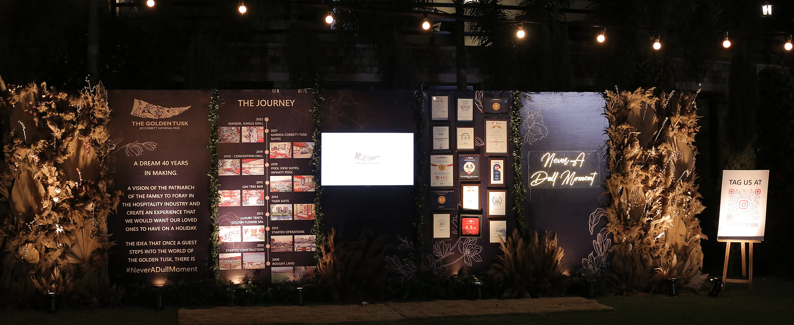 A dimly lit stage with various awards on display along with the venues of the Golden Tusk Resort.
