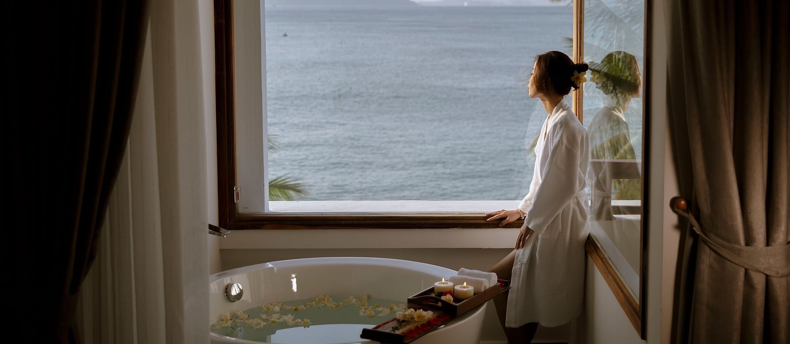 A woman looking at the beautiful view from the window - Alibu Resort