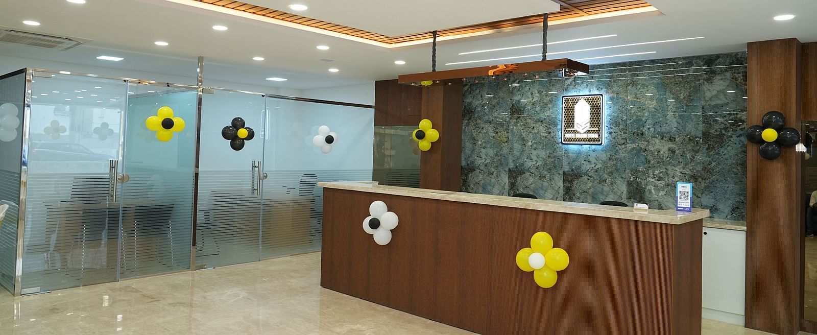 corner view image of the reception area with the logo of the hotel illuminated behind the desk - Hotel Grand Sigma