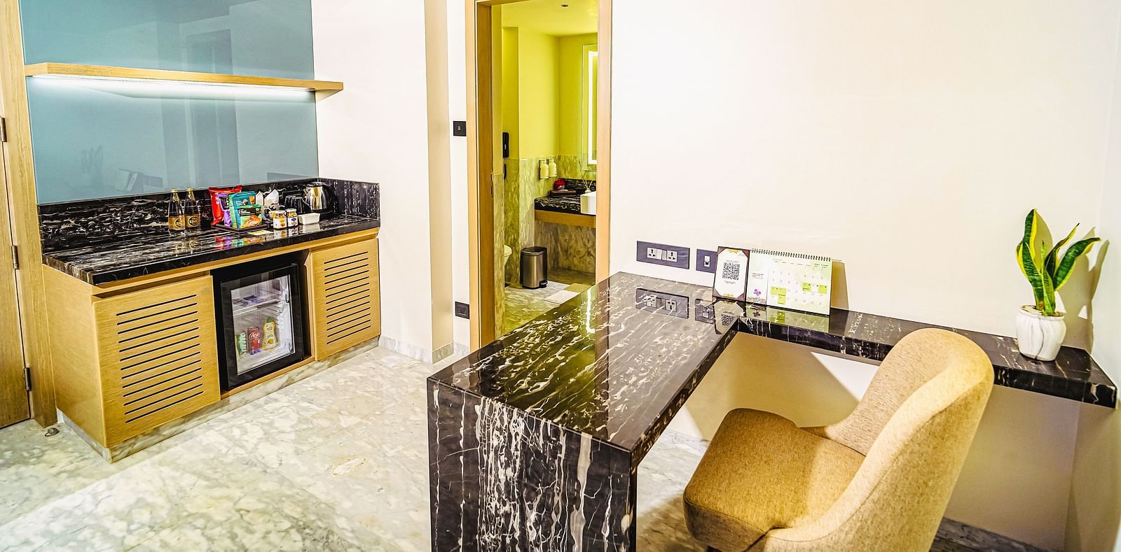 An image of the living room with a desk and a minibar in our Deluxe Room
