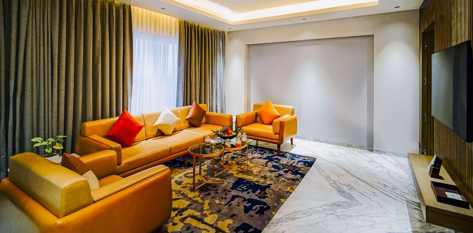 An image of the living room in our Executive Suite with couches placed in front of a wall-mounted television