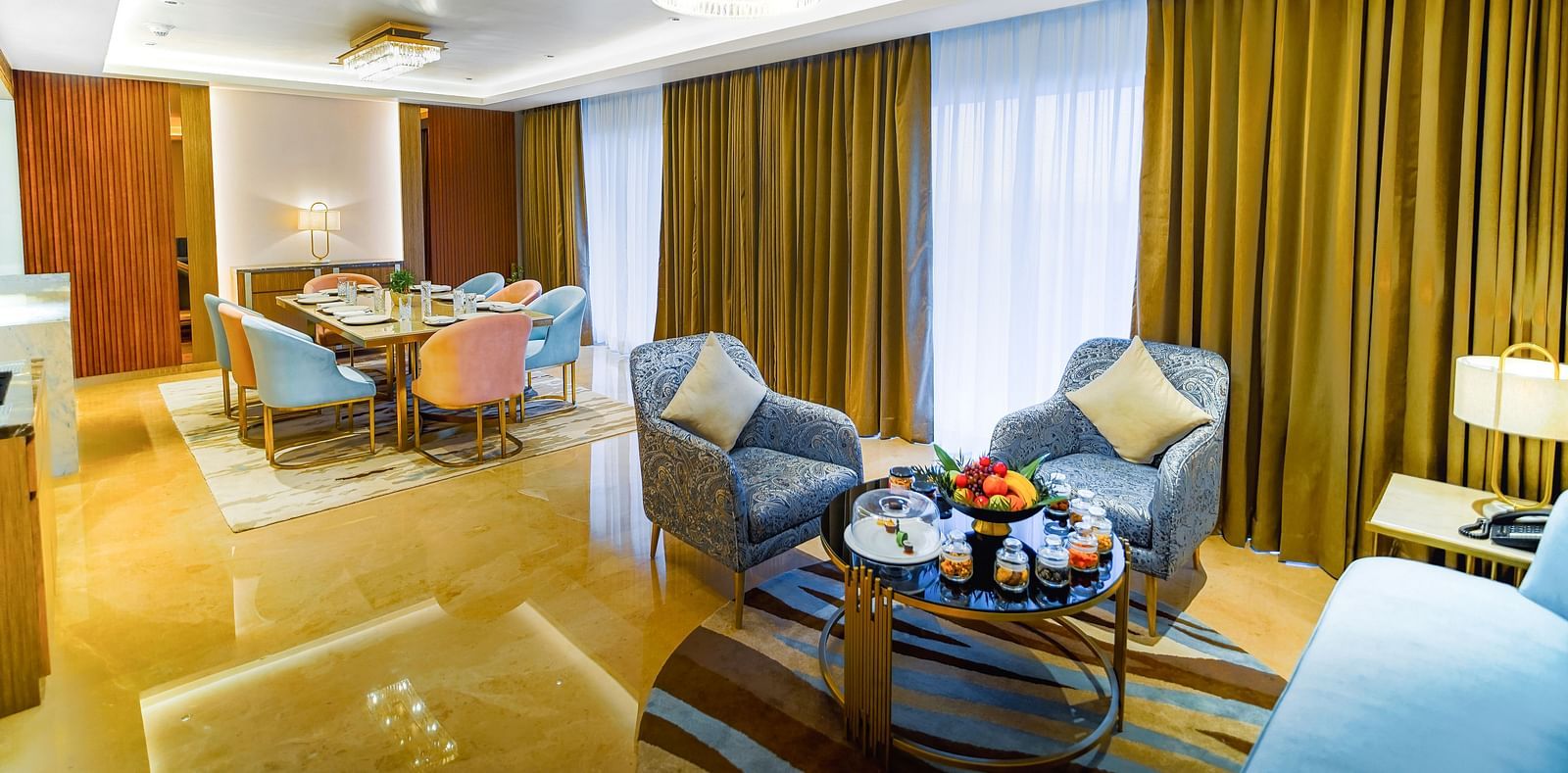 A separate dining room available at out hotel room in Madurai with coffee tables, sofas and a dining table