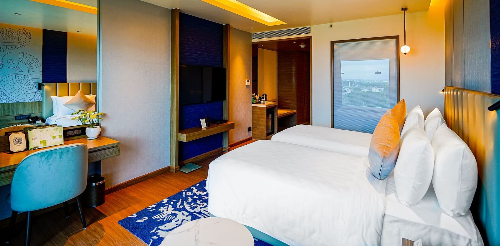 An image of Grand Club Temple View Room in Madurai with a twin bed, a work desk and hanging ceiling lamps