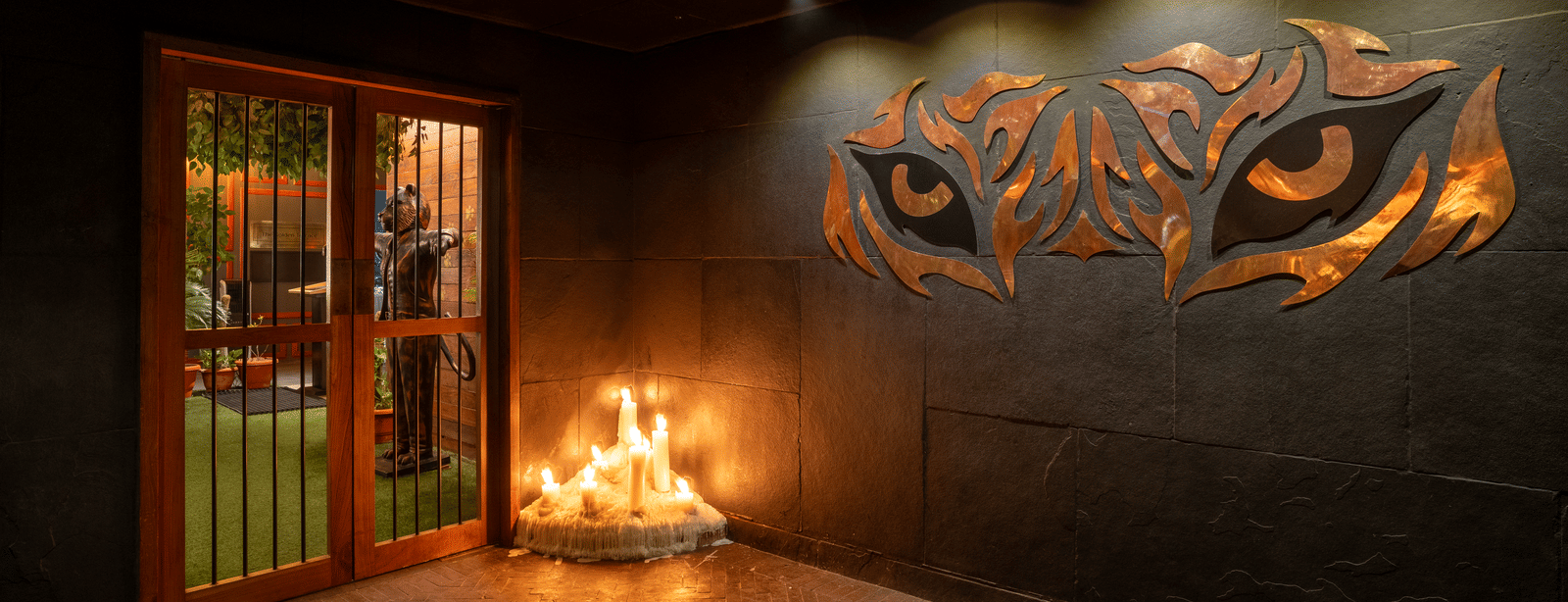 A wall with glowing tiger eye artwork beside a fire installation at Infiniti Hotel, Indore.-HDR