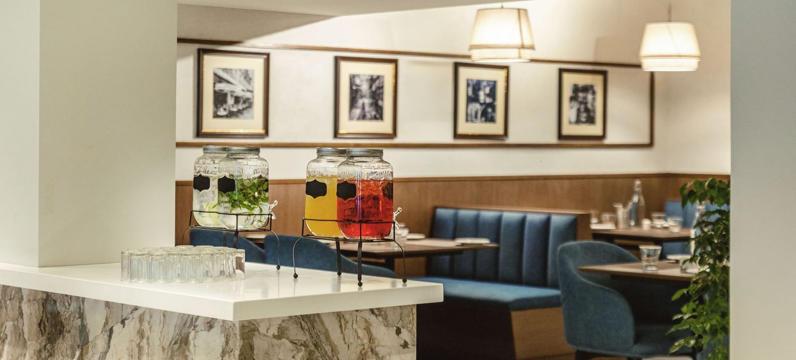 A dining area at Mango Hill Central, Chennai, with booths and a white counter in the foreground. There are framed pictures on the wall.