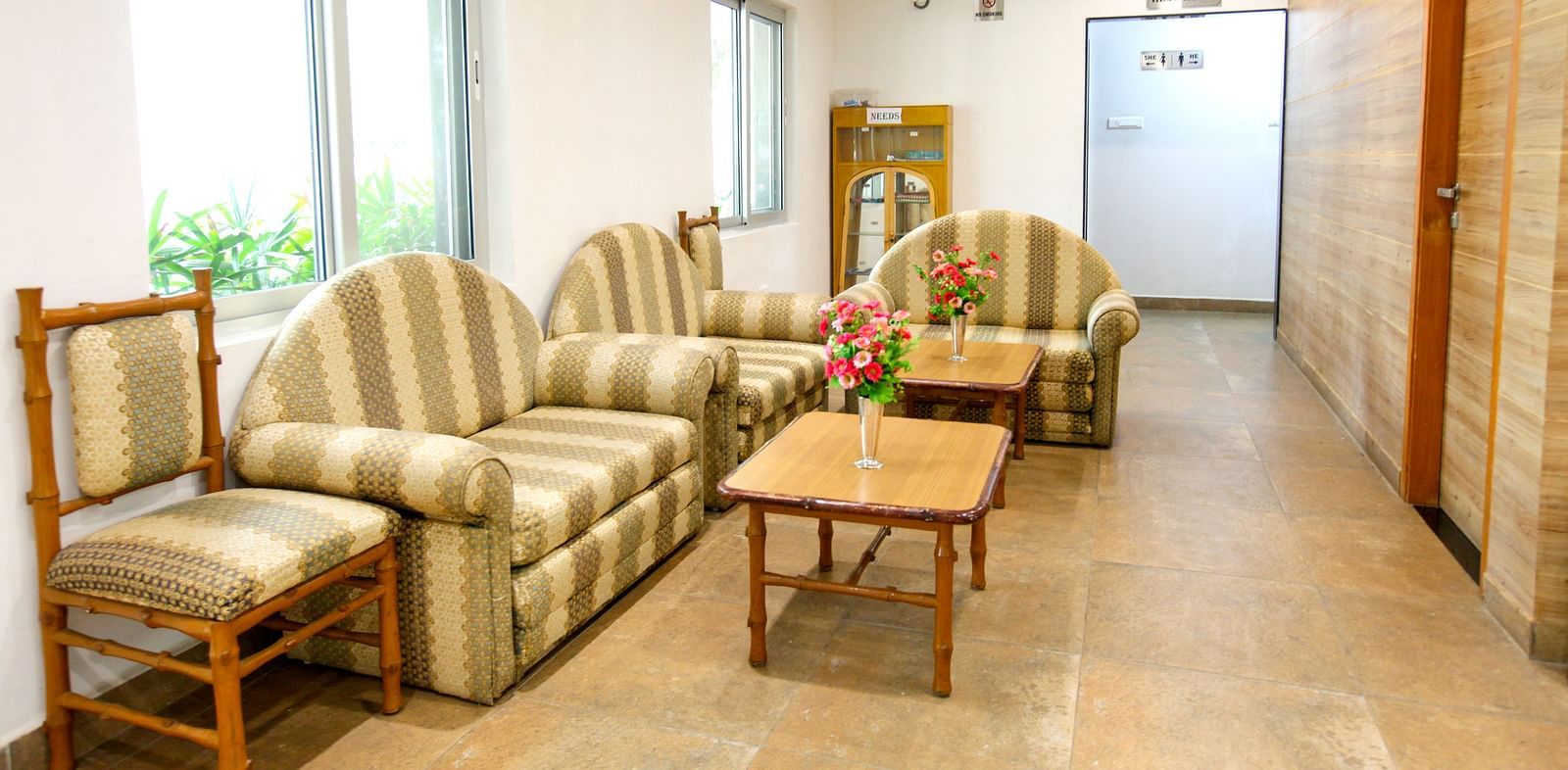 Sofas and chairs placed around a table at Greens Inn - Comfortable Lounge in Hyderabad.