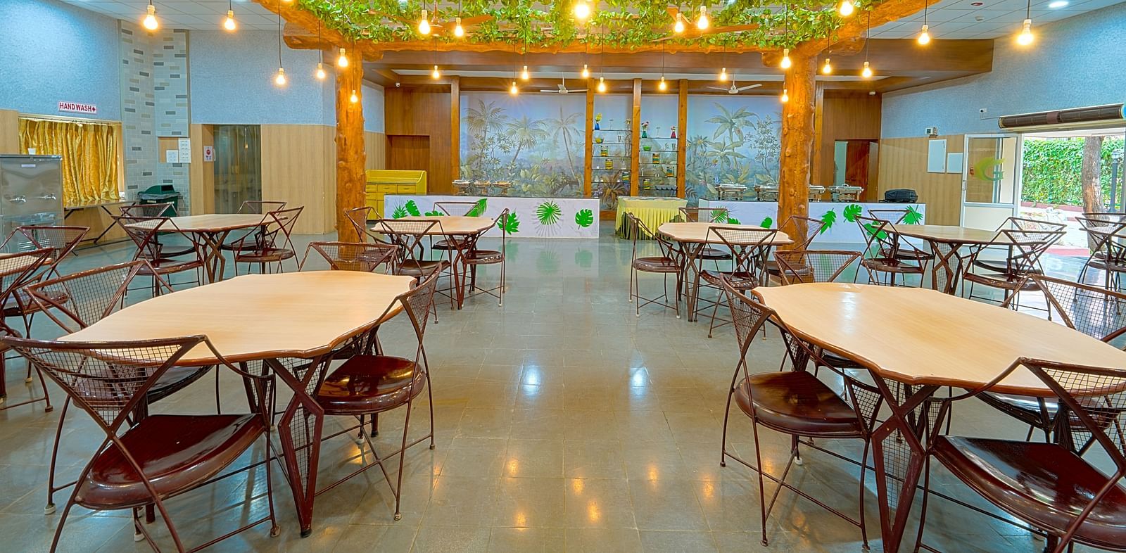 Dining tables and chairs placed in Greens Inn Restaurant - Top Restaurant in Hyderabad.
