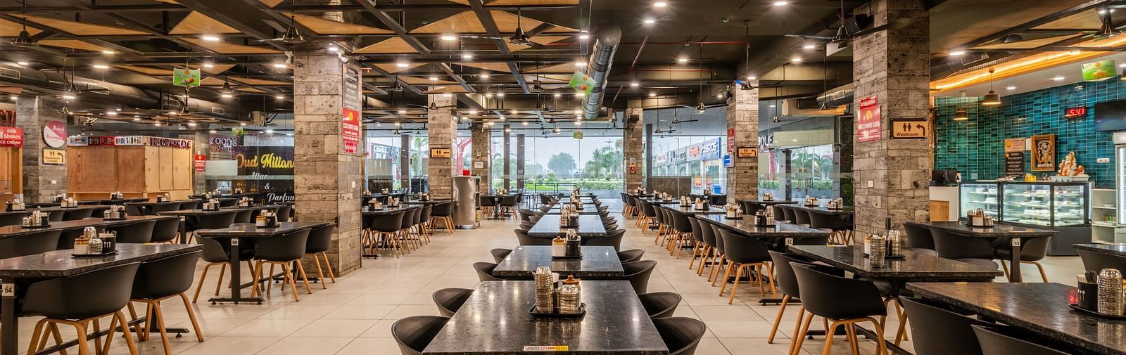 Grand entrance view of the dining hall with polished flooring and open seating at Hotel Highway King, Bilaspur.