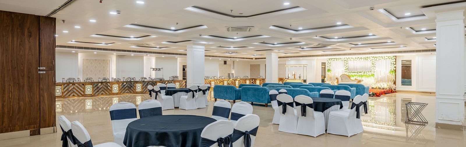Event space with cluster seating arrangement and navy bows tied around at Hotel Highway King, Bilaspur.