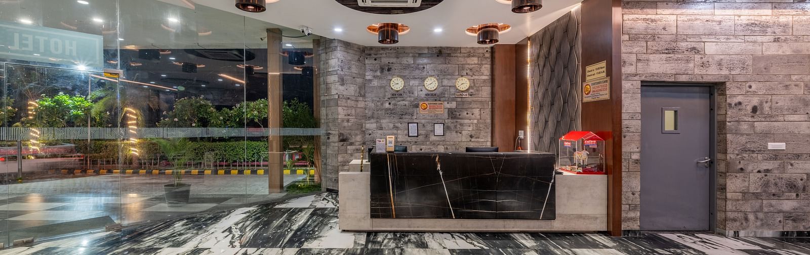 Reception area with black marble desk and contemporary decor at Hotel Highway King, Bilaspur.