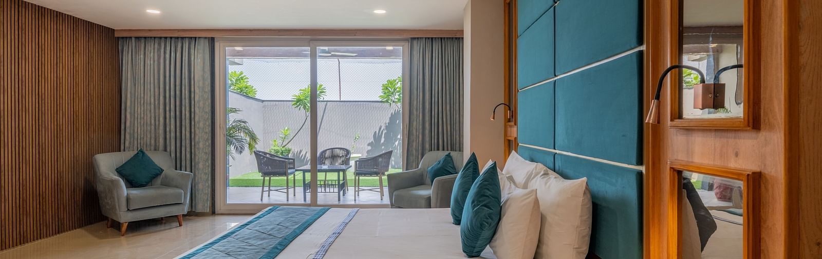 A well-appointed guest room with a large bed and a view of the outside area at Hotel Highway King Shahpura.