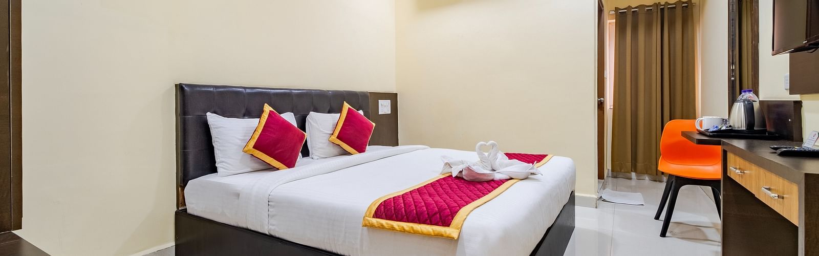 Grand room with a cosy bed and wall-mounted TV at Lemonridge Hotels