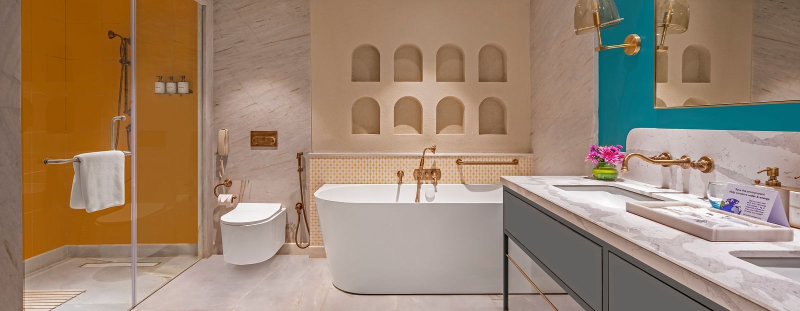 An image of the bathroom featuring a large bathtub, a separate glass-enclosed shower, and a double vanity.