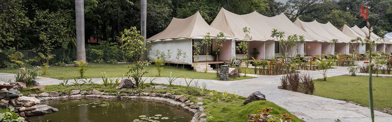 exterior image of the luxury tent villas nestled amidst serene greenery at aranya vilas