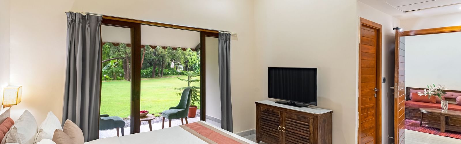 image of the bedroom in the luxury family suite featuring a king size bed with a television placed opposite to the bed at aranya vilas in udaipur