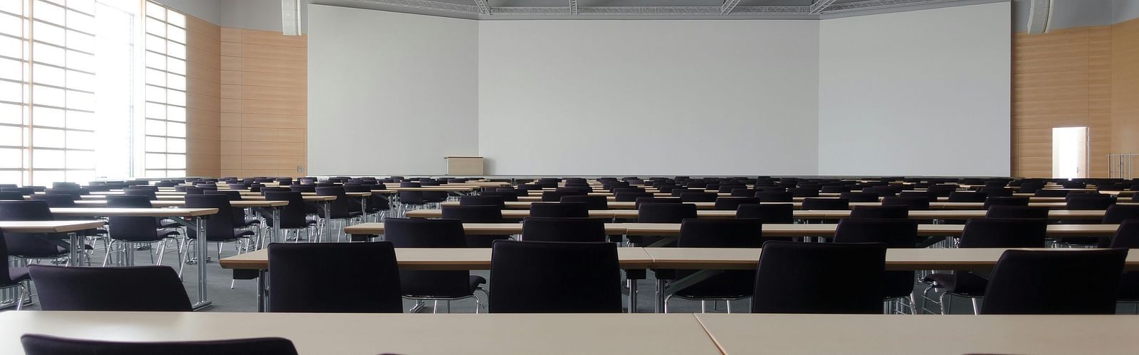 an image of conference hall with chairs and tables 