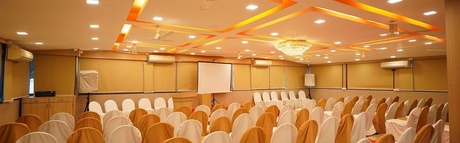 an image of a event hall with designed ceiling illuminating orange lights at  City Centre Residency, Bangalore