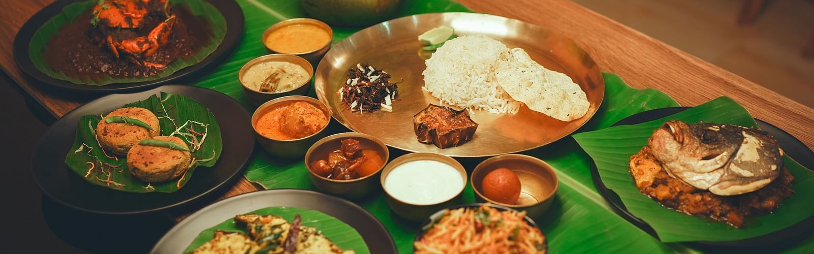 image featuring a beangli meal platter along with several bengali delicacies served on banana leaves - Dip Holidays, Birbhum