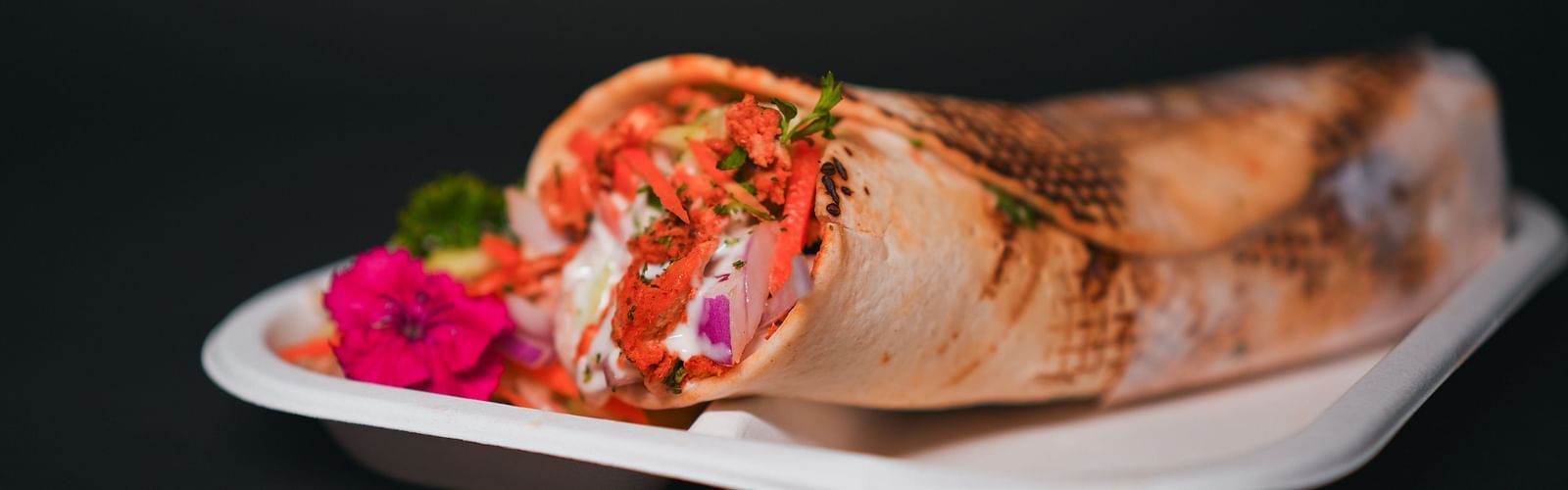 Freshly prepared shawarma wrap served on a tray at D Café in Dip Holidays, filled with vibrant vegetables and garnished for a flavourful presentation.